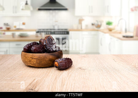 Dried dates fruit in bowl, background is kitchen Stock Photo