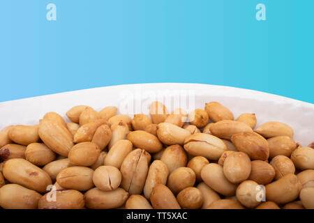 Close up of roasted peanuts on isoalted blue background Stock Photo