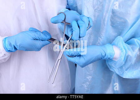 Surgeon's hands holding different instruments close up Stock Photo