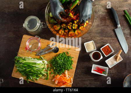 Various food items and ingredients for making spicy kimchee a favorite healthy fermented Korean condiment. Colorful and delicious. Hands preparing. Stock Photo