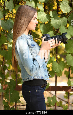 Beautiful young photography take photos outdoors in park Stock Photo