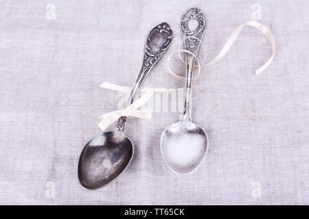 Metal spoons on white fabric background Stock Photo