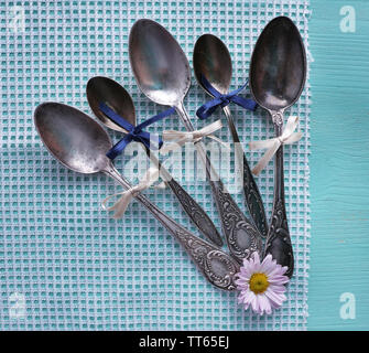 Metal spoons on white napkin on light blue background Stock Photo