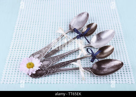 Metal spoons on white napkin on light blue background Stock Photo
