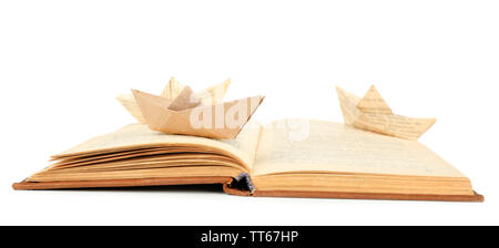 Origami boat on old book, isolated on white Stock Photo