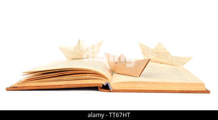 Origami boat on old book, isolated on white Stock Photo