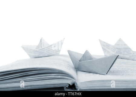 Origami boats on old book, on white background Stock Photo