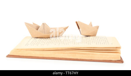 Origami boat on old book, isolated on white Stock Photo