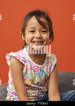Asian kid smiling portrait. Color background. Stock Photo
