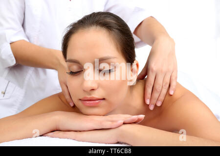 Masseur doing massage on woman body isolated on white. Stock Photo