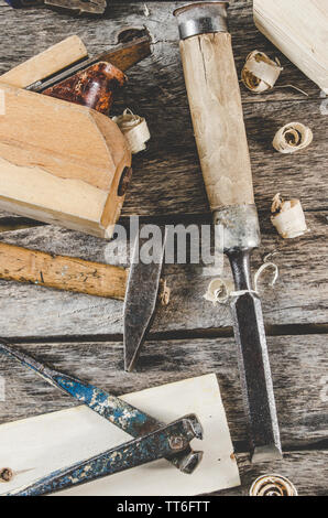 The carpenter tools on a wooden bench, a planer, chisel, hammer, tongs, top view Stock Photo