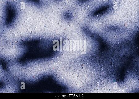 Colored asphalt surface with the shadow of tree branches close up. Abstract background Stock Photo
