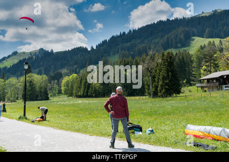 Schwarzsee, FR / Switzerland - 1 June 2019: instructors and students work together during a training course for paragliding in the Swiss Alps of Fribo Stock Photo