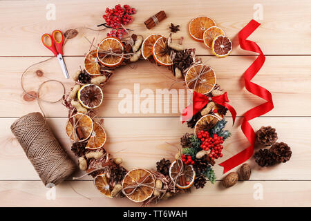 Christmas wreath with materials for decorating on wooden background Stock Photo