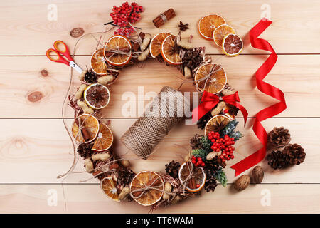 Christmas wreath with materials for decorating on wooden background Stock Photo