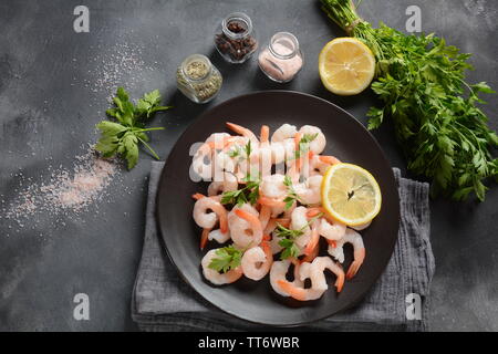 Fresh prawns. Raw shrimps, prawns in a plate on a dark background. Seafood. Stock Photo