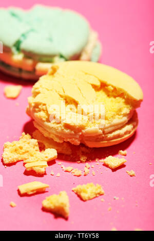 Bright tasty broken macaroons cakes on pink background Stock Photo