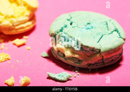 Bright tasty broken macaroons cakes on pink background Stock Photo