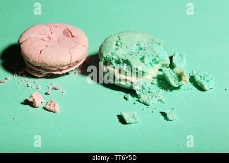 Bright tasty broken macaroons cakes on color background Stock Photo
