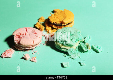 Bright tasty broken macaroons cakes on color background Stock Photo