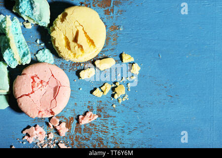 Bright tasty broken macaroons cakes on old wooden background Stock Photo