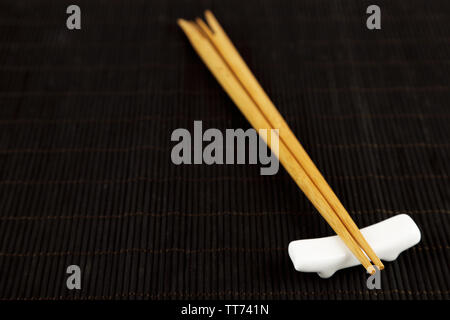 Pair of chopsticks on black bamboo mat background Stock Photo