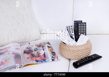 Many remote control devices on sofa Stock Photo
