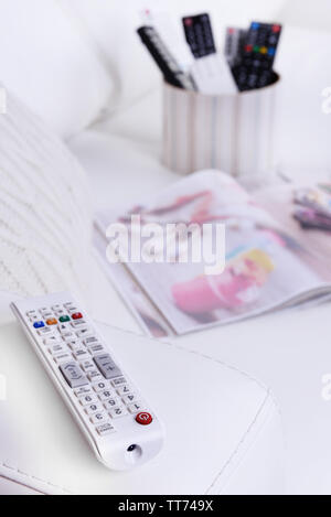 Many remote control devices on sofa Stock Photo