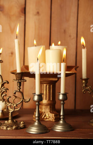 Many Burning Candles on Aged Wooden Table Stock Photo - Alamy