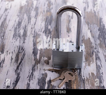 Padlock with keys on wooden background Stock Photo