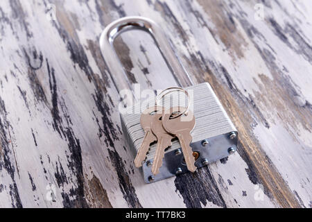 Padlock with keys on wooden background Stock Photo