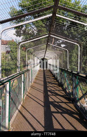 Diminishing perspective view of empty overpass with protection mesh metal fence. Stock Photo