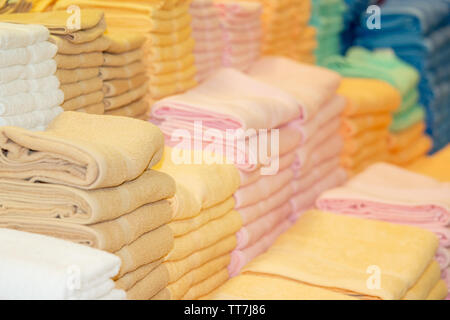 Stack of the multicolored towels on shelf Stock Photo
