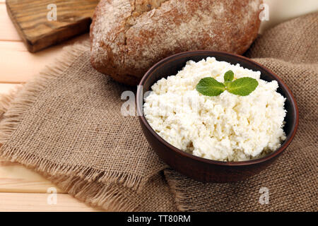 Cottage cheese in bowl with bread on table close up Stock Photo