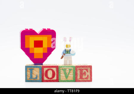 lego bunny suit guy with easter egg and piece offering heart shape.  Lego minifigures are manufactured by The Lego Stock Photo