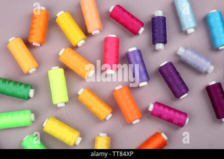 Multicolor sewing threads on wooden background Stock Photo