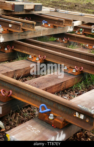 Sections of new rail track awaiting laying. Stock Photo