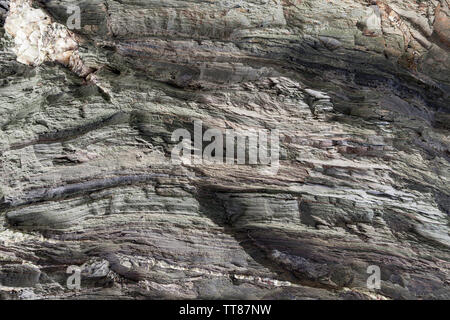 Natural stone texture. Textured surface of natural rock, where you can see layers of rock and white crystals formed over time. Stock Photo