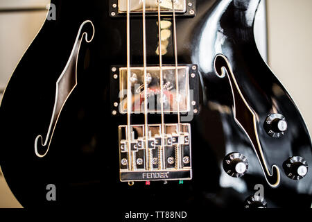 black jazz bass guitar on the wall on sale of a music store Stock Photo