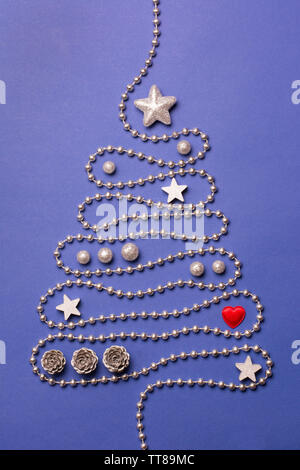 Christmas tree concept with silver bead chain, silver stars, cones, globules and red heart on dark blue background Stock Photo