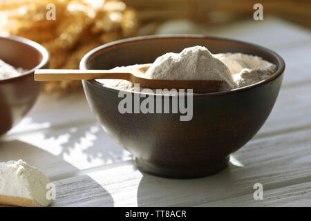 Flour in bowls on wooden planks background Stock Photo