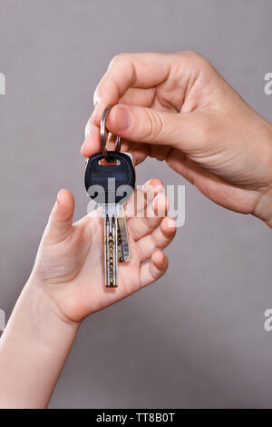 hand of adult hanging house keys to child Stock Photo