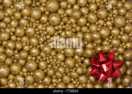 Christmas background with big and small golden glitter balls and big red ribbon star Stock Photo