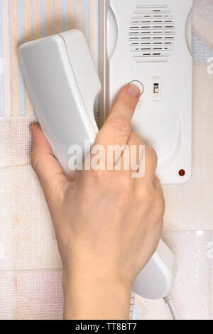 hand pressing a button on the intercom at home, closeup Stock Photo