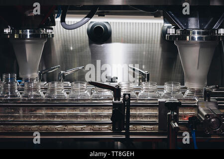 pharmaceutical industry, medicine pills are filling in the plastic bottle on production line machine conveyor at the medical factory. selective focus. Stock Photo