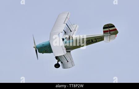 Bücher Jungmann G-BSAJ with the 1936 Berlin Olympics colour scheme flying at the Shuttleworth Flying Festival Airshow on the 2rd June 2019 Stock Photo