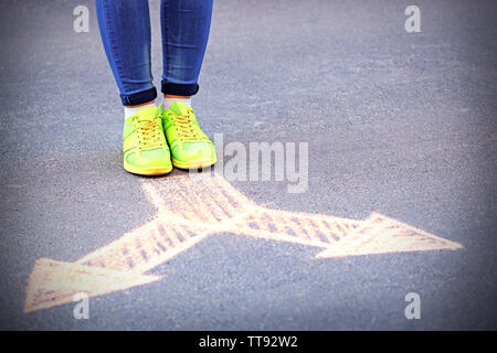 Female feet and drawing arrows on pavement background Stock Photo