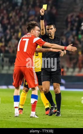 Brussels, Belgium - March 21, 2019.  Romanian referee Ovidiu Hategan showing yellow card to Russia national team midfielder Aleksandr Golovin during U Stock Photo