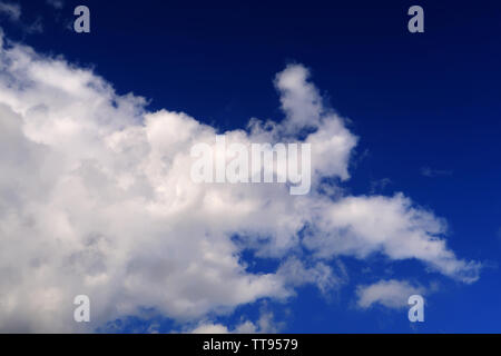 Whispy clouds spreading over a deep blue sky Stock Photo