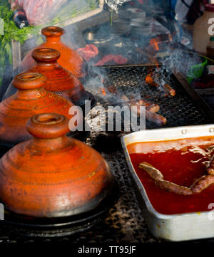 cooking in traditional moroccan tajine pot over open fire Stock Photo